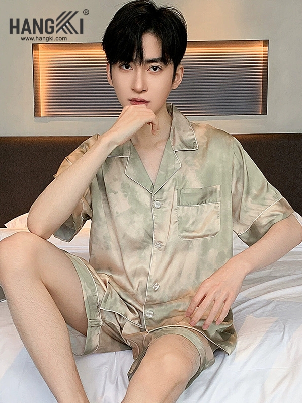 Nam giới mặc bộ đồ ngủ lụa ngắn tay màu loang xanh be thương hiệu Hangki ngồi trên giường