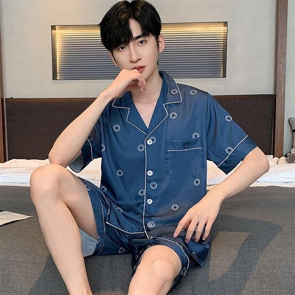 Bộ pijama nam lụa màu xanh navy họa tiết tròn tay ngắn quần short ngồi trên giường