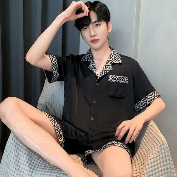 Bộ đồ ngủ nam lụa màu đen tay ngắn quần short viền họa tiết ngồi trên ghế