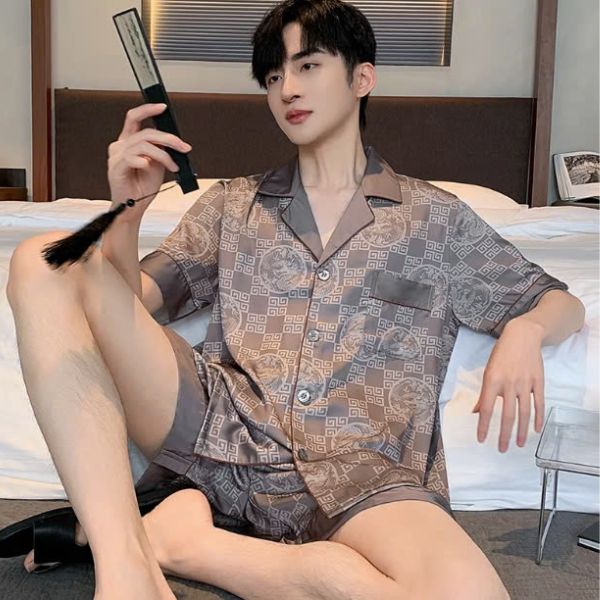 Bộ đồ ngủ nam lụa ngắn tay màu nâu họa tiết hình học ngồi trên giường trong phòng ngủ
