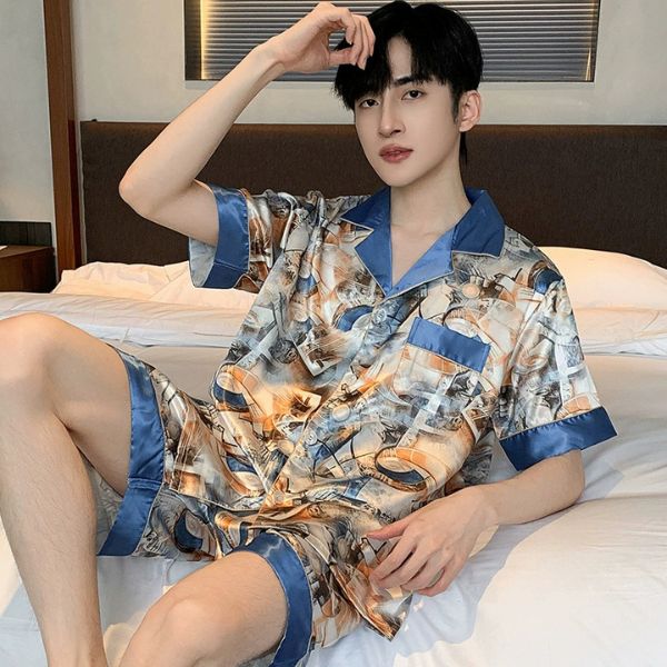 Bộ đồ ngủ lụa nam tay ngắn quần short họa tiết phối viền xanh ngồi trên giường
