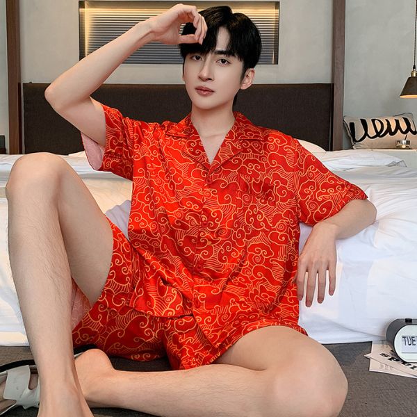 Bộ đồ ngủ nam lụa màu đỏ họa tiết mây cuộn, tay ngắn quần short, người mẫu ngồi trên giường