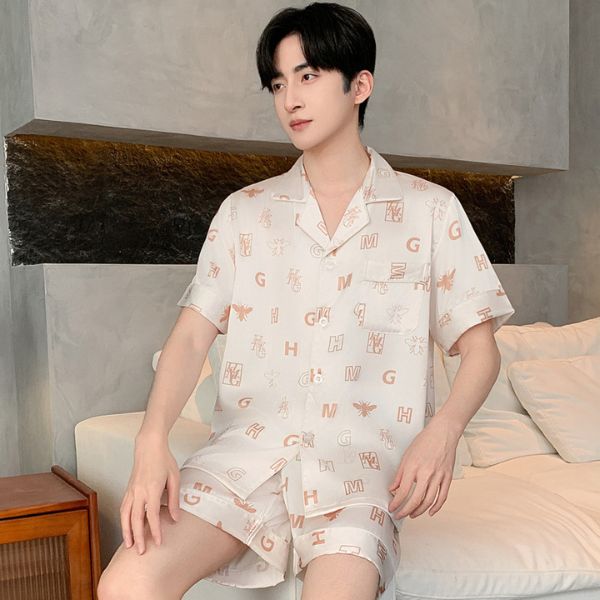 Nam giới mặc bộ đồ ngủ lụa ngắn tay màu be họa tiết chữ cái ngồi trên ghế sofa