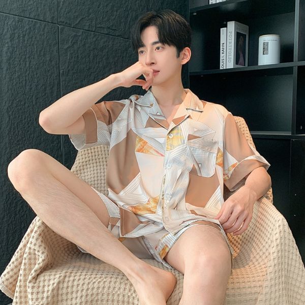 Bộ đồ ngủ nam lụa màu be họa tiết hình học, tay ngắn quần short, người mẫu ngồi trên ghế thư giãn