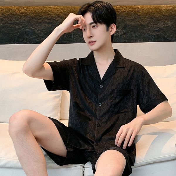 Bộ đồ ngủ nam tay ngắn màu đen họa tiết nhẹ, chất liệu mỏng nhẹ, người mẫu ngồi trên ghế sofa