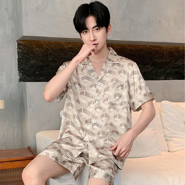 Nam giới mặc bộ pijama lụa ngắn tay họa tiết hình khối màu be ngồi trên ghế sofa