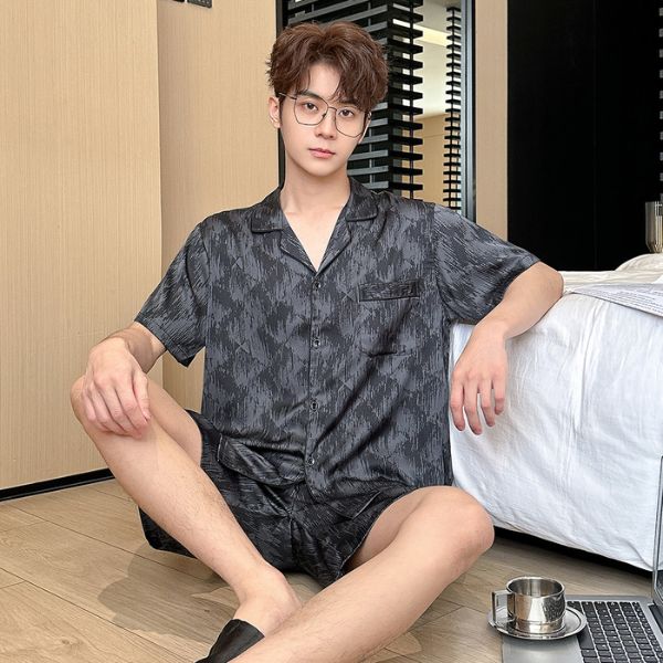 Bộ đồ ngủ nam lụa màu xám họa tiết ngắn tay quần short, dáng rộng thoải mái ngồi cạnh giường