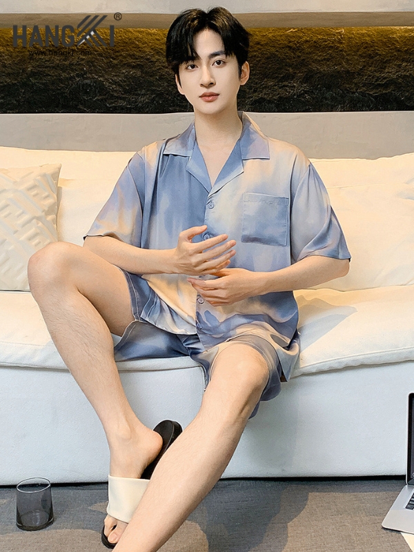 Nam giới mặc bộ đồ ngủ lụa tay ngắn màu xanh loang ngồi trên sofa trong phòng khách